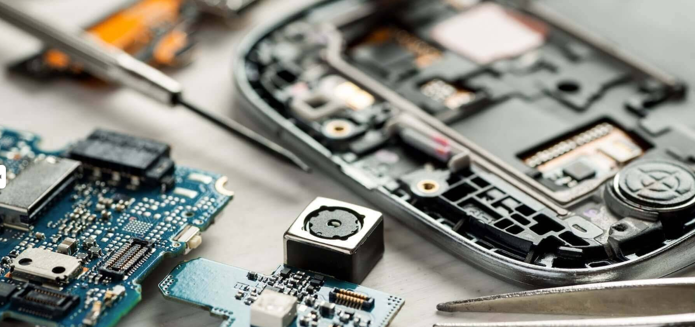 Disassembled phone components and circuit boards on a Fix Squad repair bench